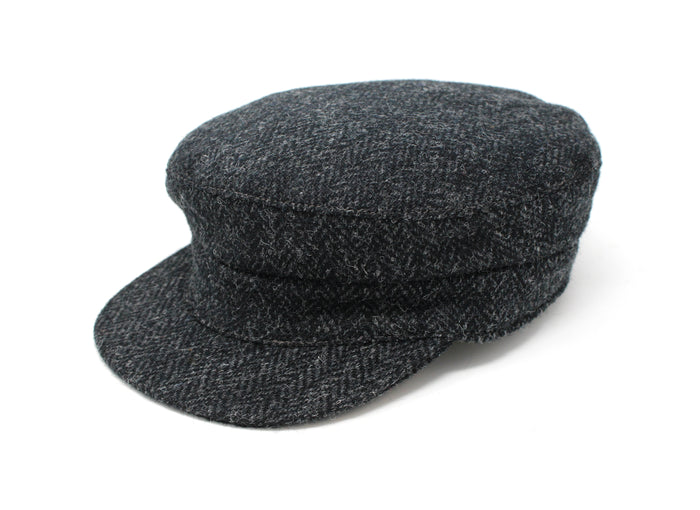 The Hanna Hats Skipper Cap Tweed is a dark gray Irish tweed newsboy cap with a short, curved brim, shown on a white background, inspired by classic mariner style.